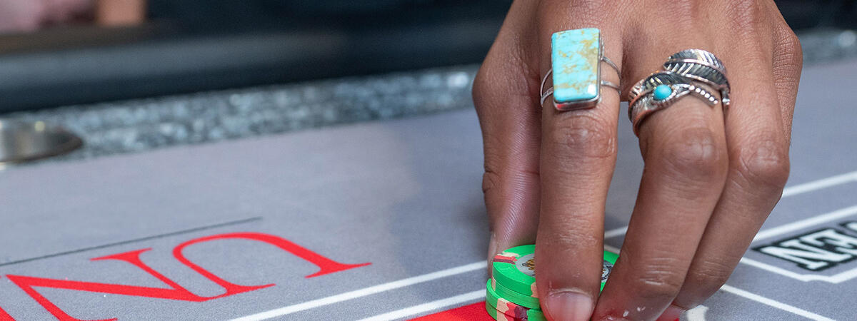 A man holding a pile of poker chips on a table