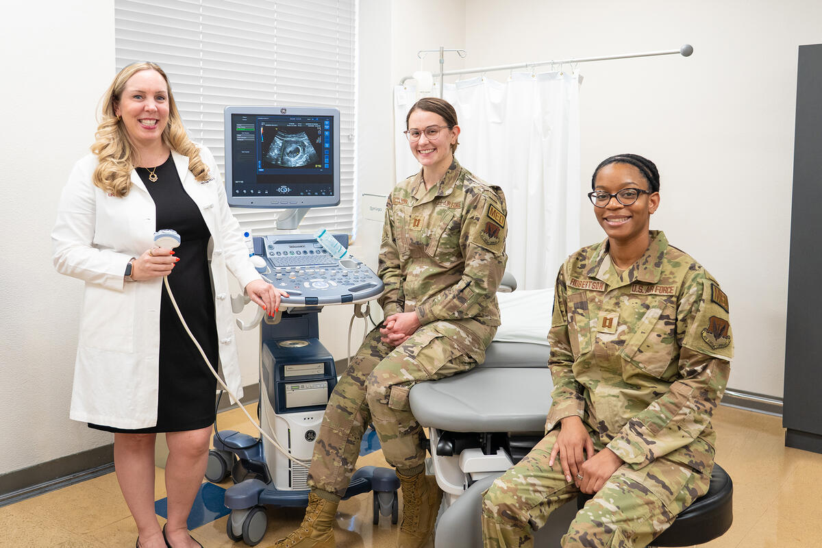 Dr. Leanne Free alongside military residents in a clinic room.