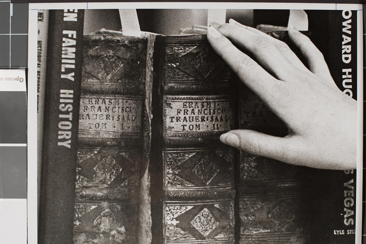 Archival photo of a hand reaching for books