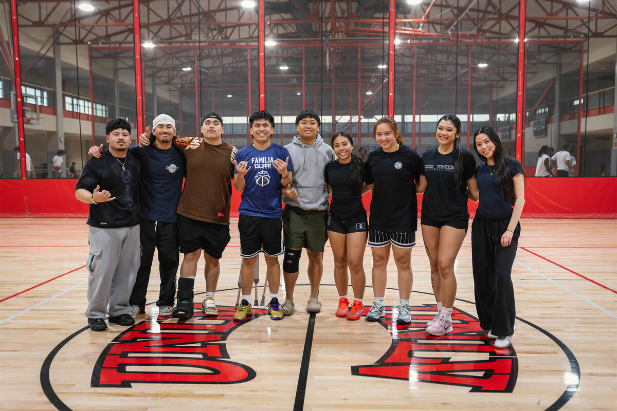 Students posing in a row at a gymnasium