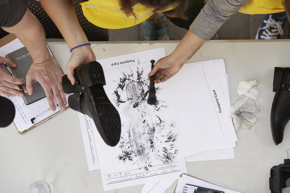 A group of people looking at a footprint card on a table