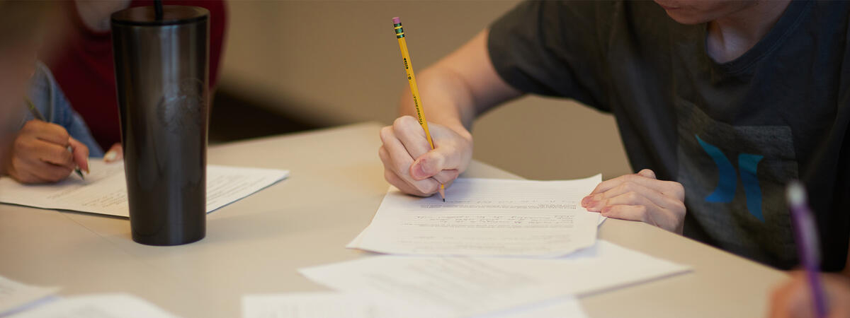 Student writing on a piece of paper