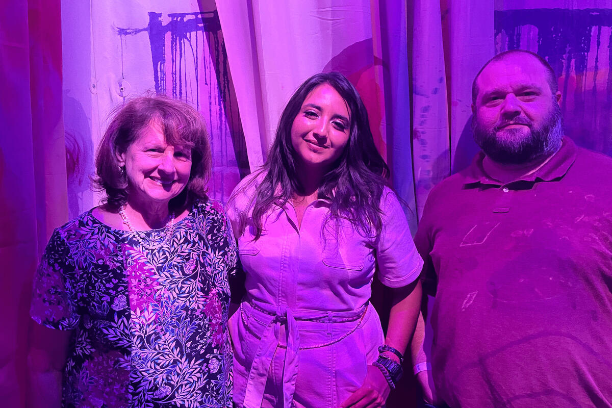 purple light filter covering three standing individuals