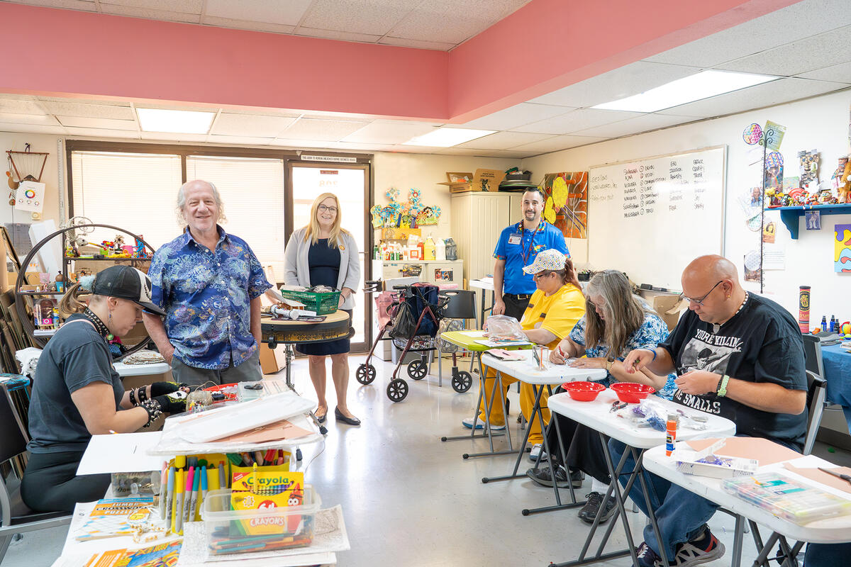 UNLV Health Mojave Counseling team members posing for a photo while clients engage in crafting activities.
