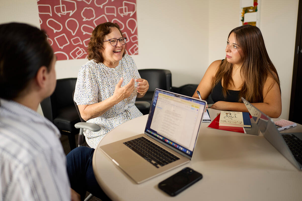 Three people gathered at a meeting table.