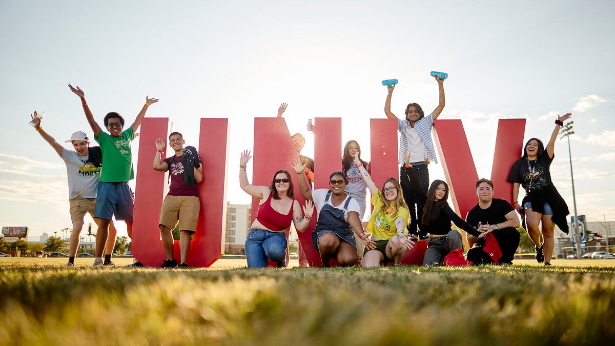 A group of students posing in front of giant letters that spells out U-N-L-V