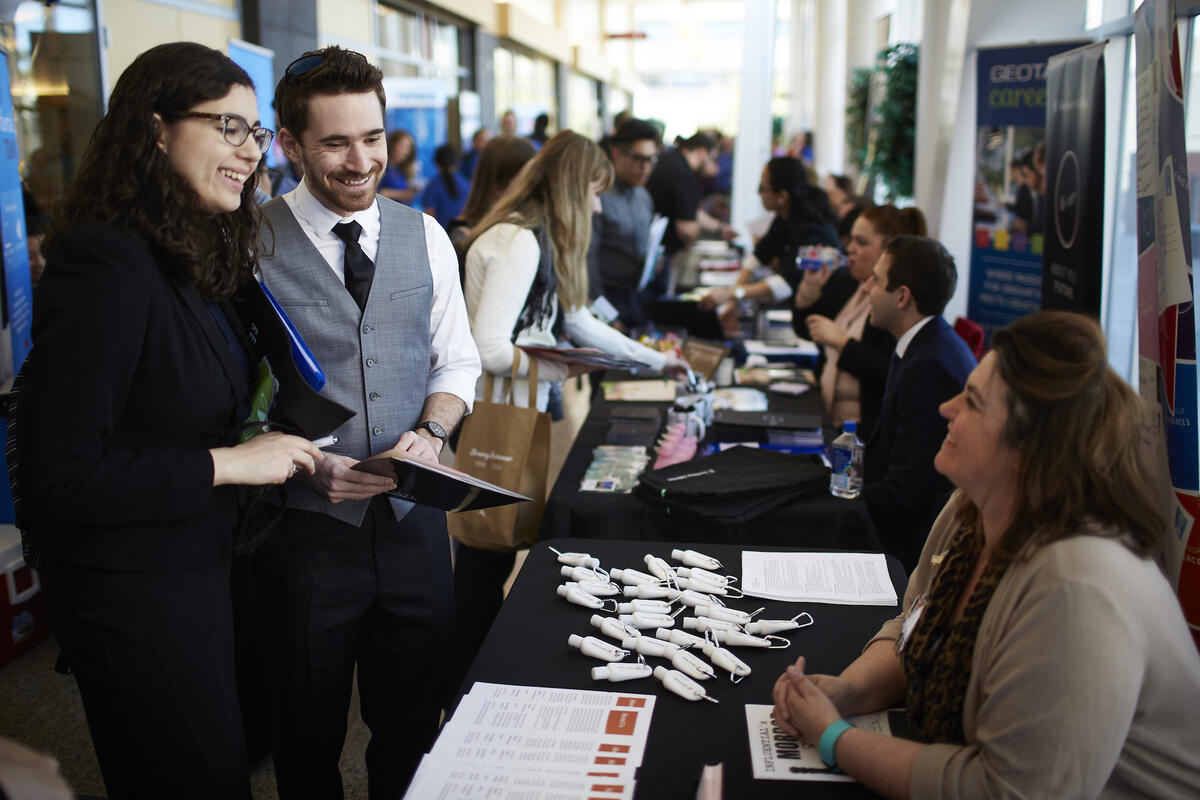 Two UNLV students speak with a potential employer at a job fair on campus.