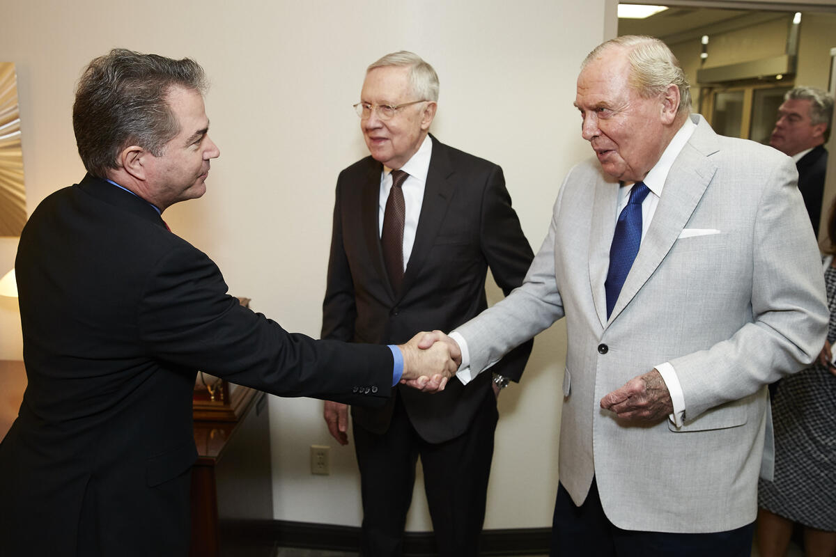 Len Dessup shakes hands with Jon Huntsman, Sr. with Sen. Harry Reid watching on