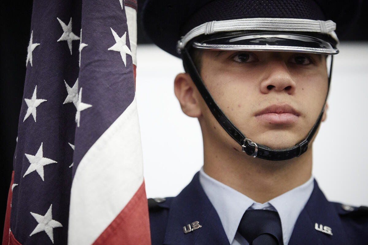 Air Force ROTC cadet standing next to American flag