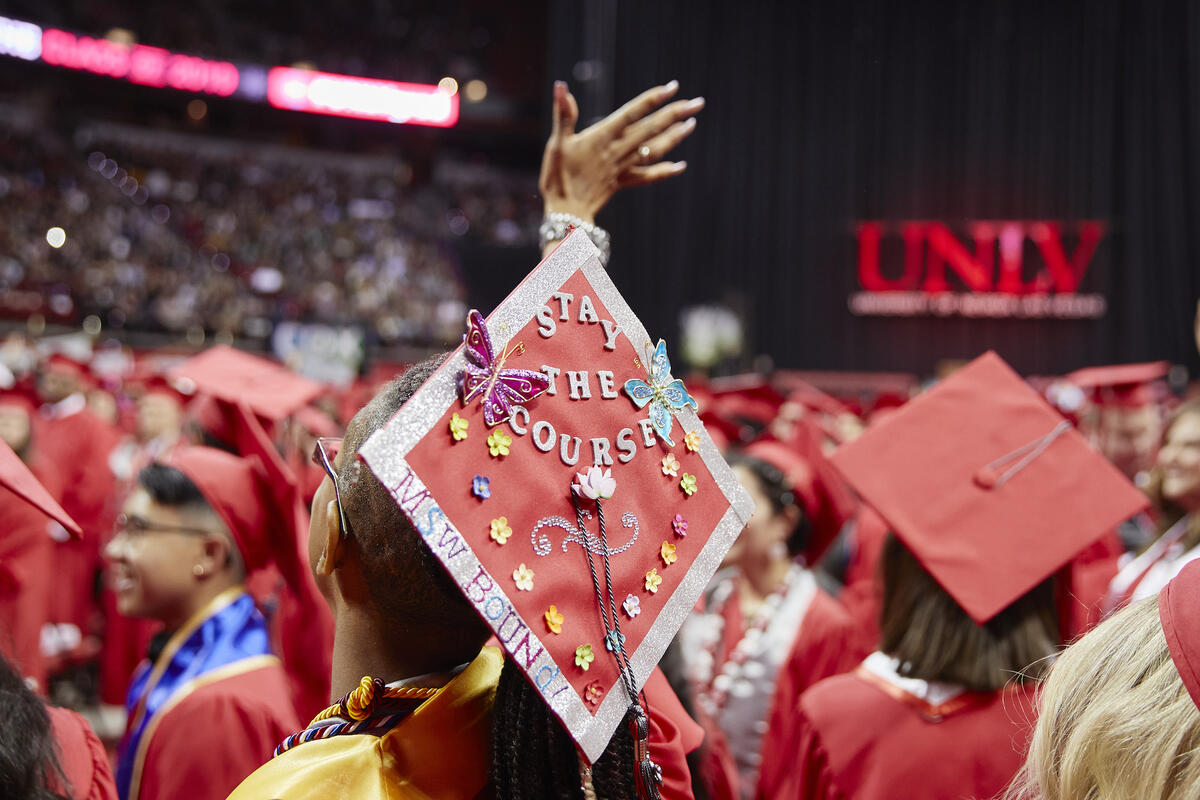 A red UNLV mortarboard decorated with the words "stay the course"