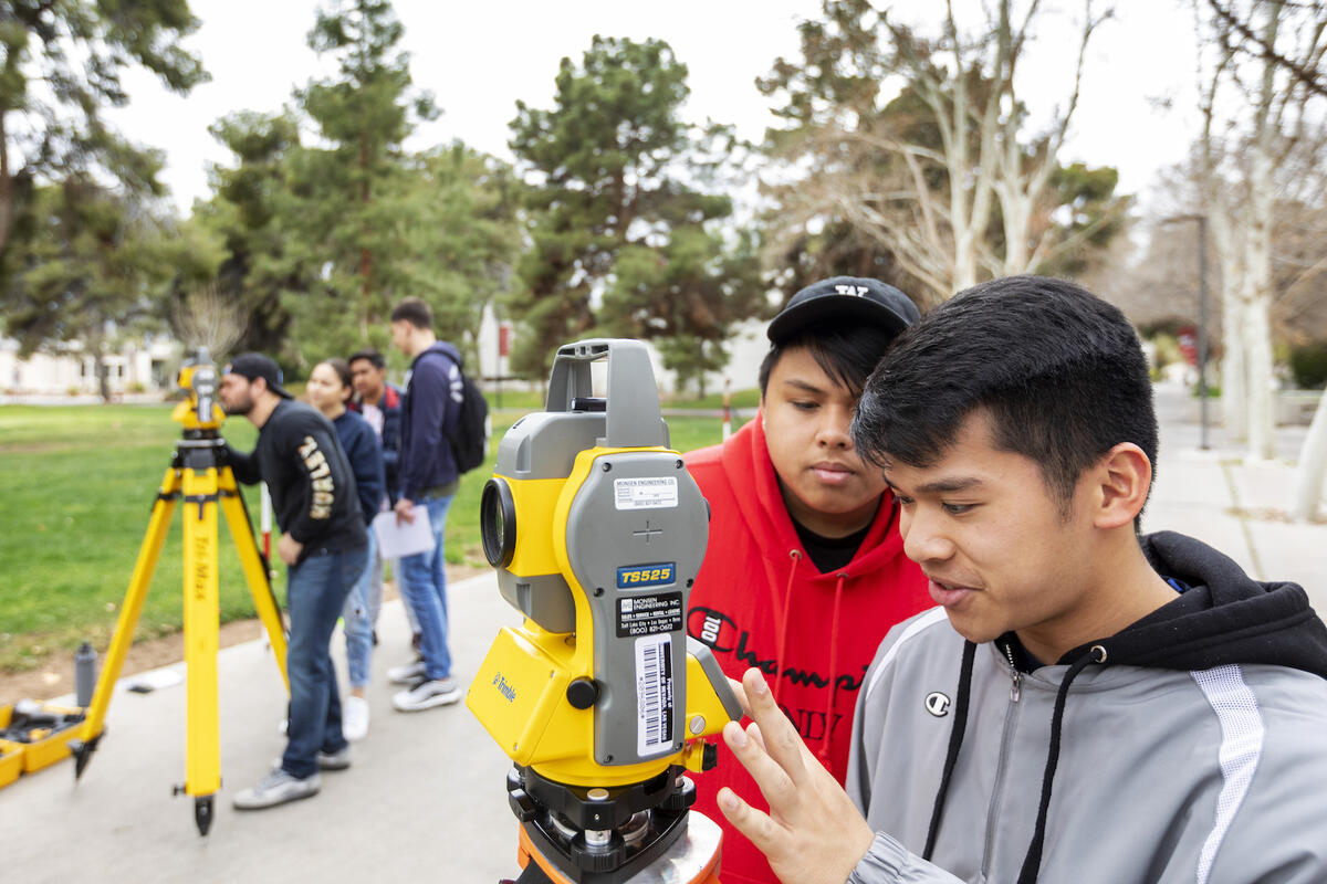 Students use a surveying instrument during a class on UNLV's campus