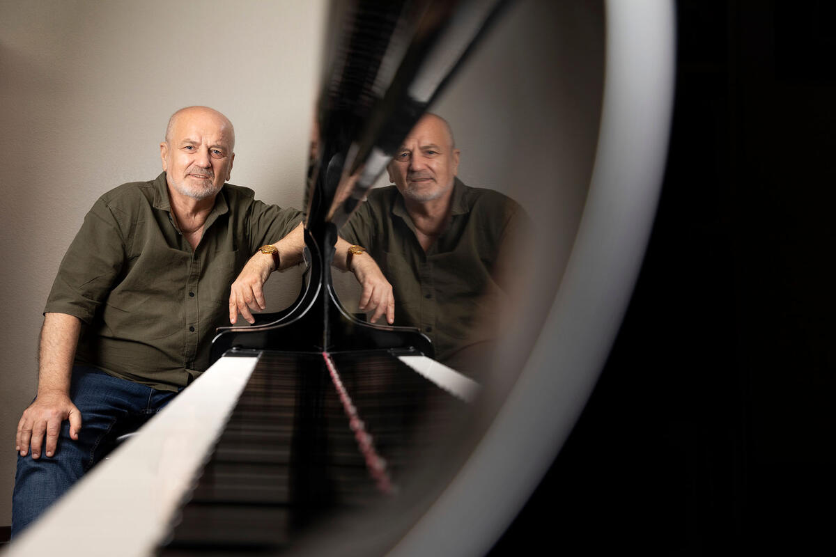 Mykola Suk poses by a piano
