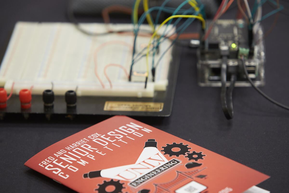 Red event program for Senior Design Competition with electrical device in background