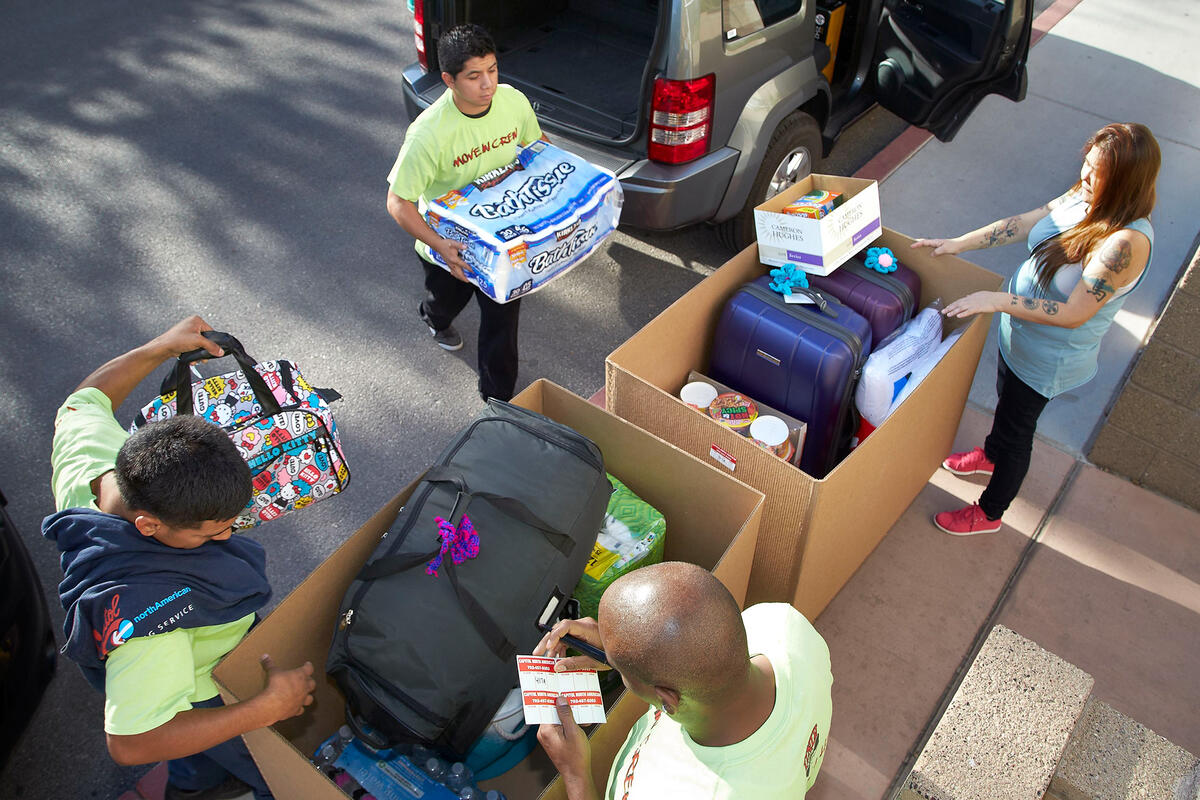 students and parents upacking boxes from cars