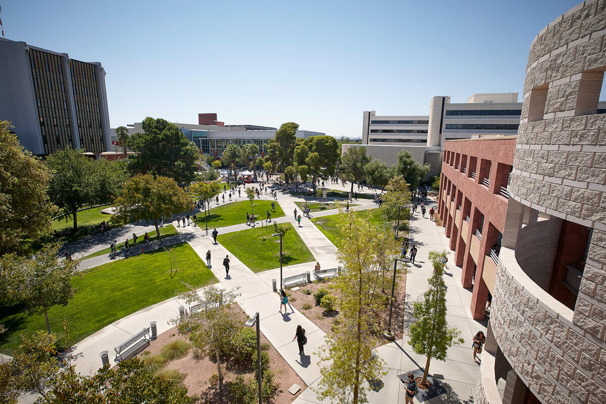 View of students walking around campus with FDH in the background