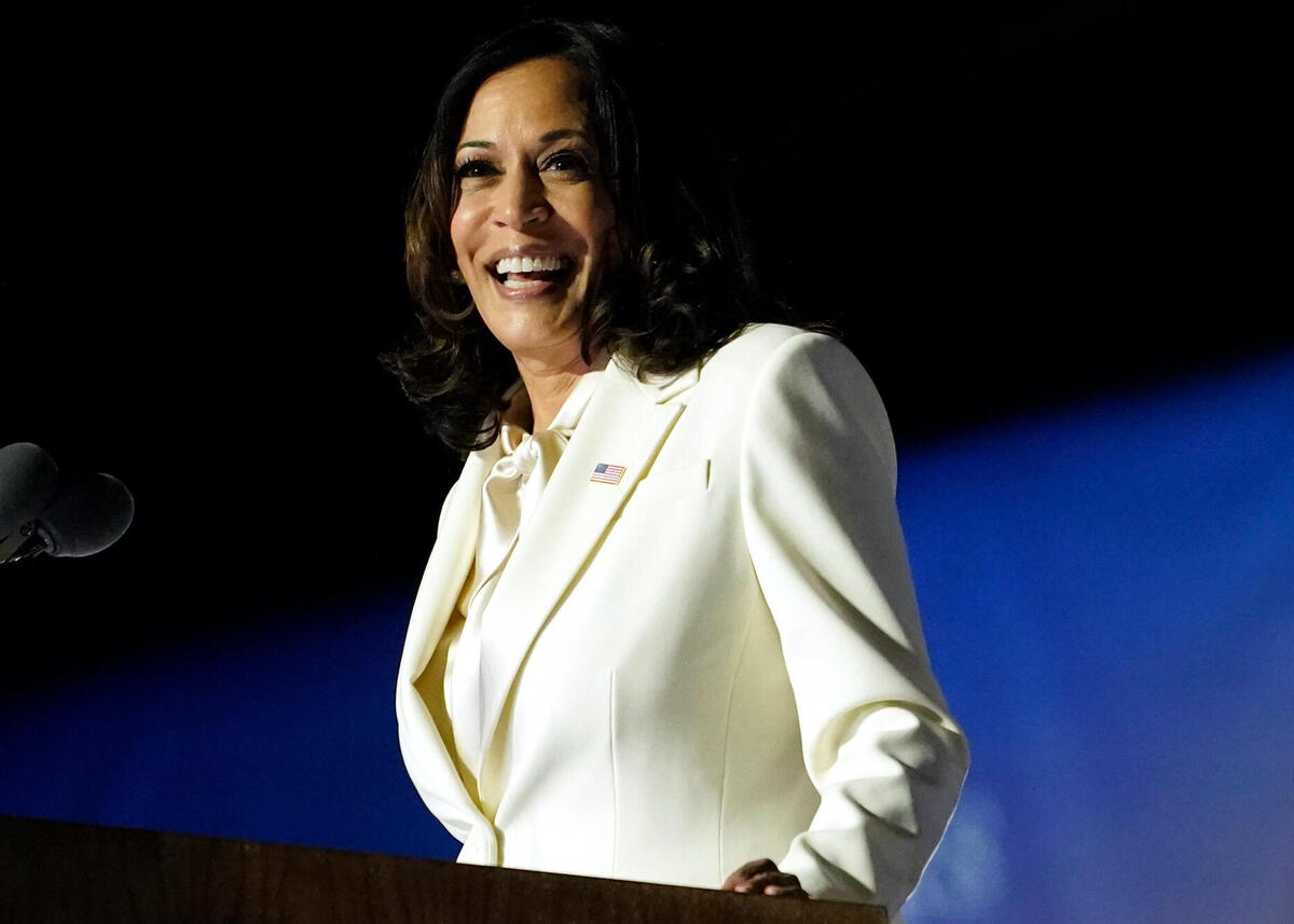 Kamala Harris wearing a white suit while giving her victory speech