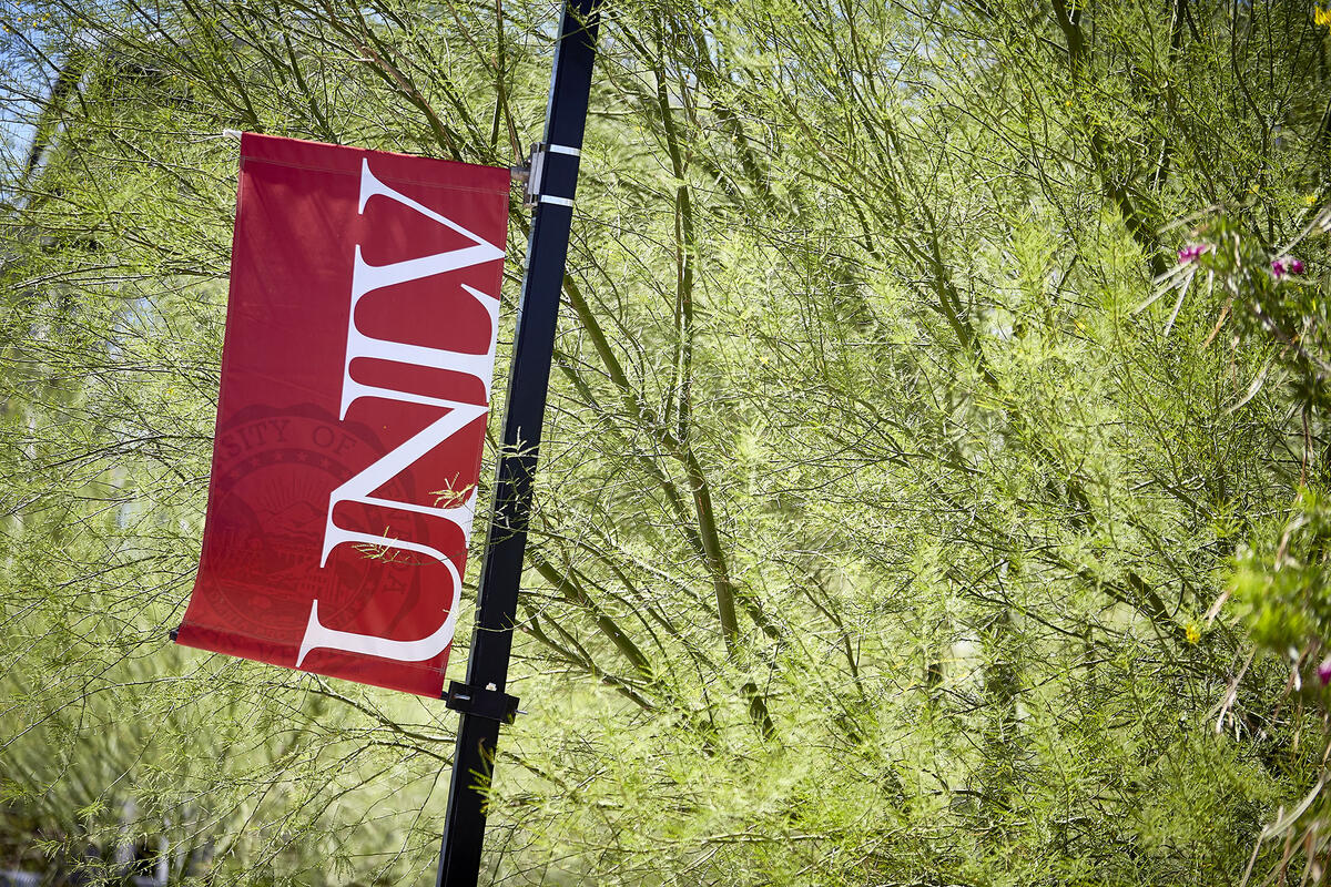 Banner with UNLV logo in front of green foliage