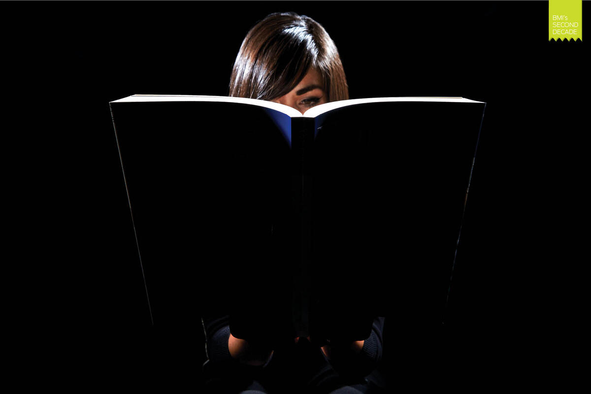 girl reads a book under a light