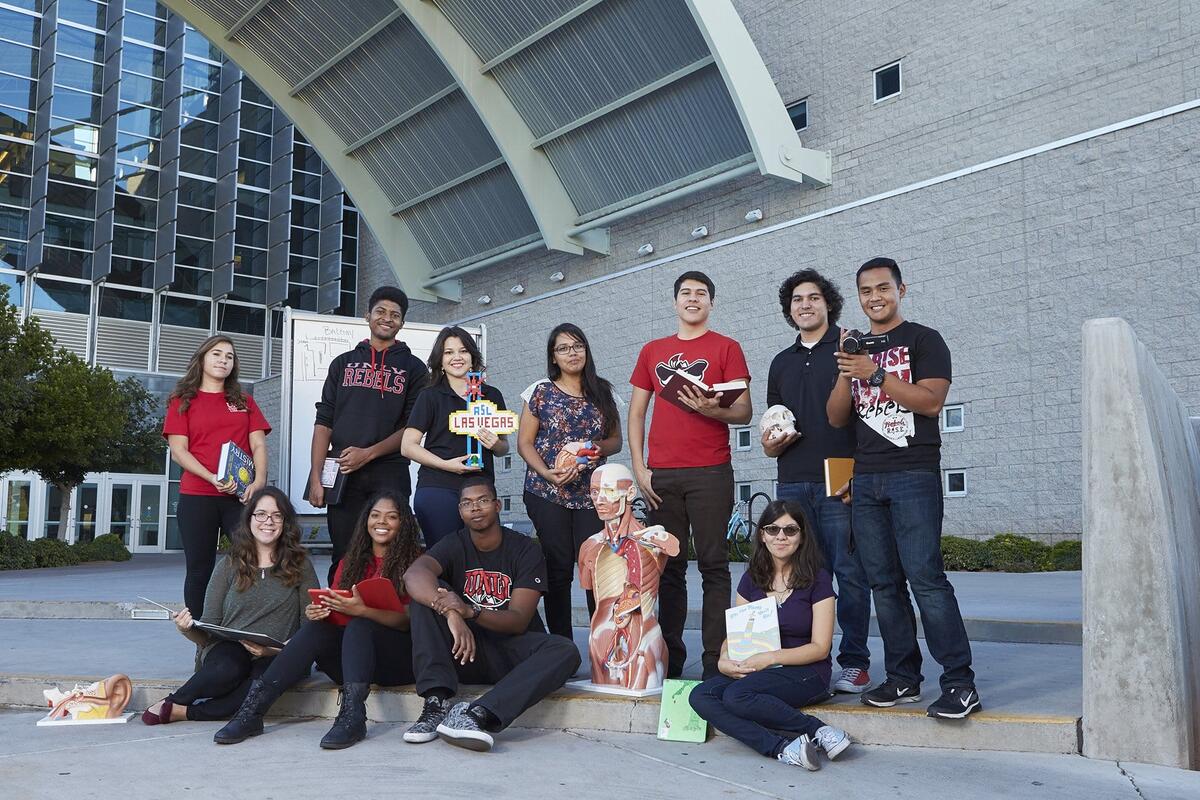 Students pose in front of the Lied Library entrance