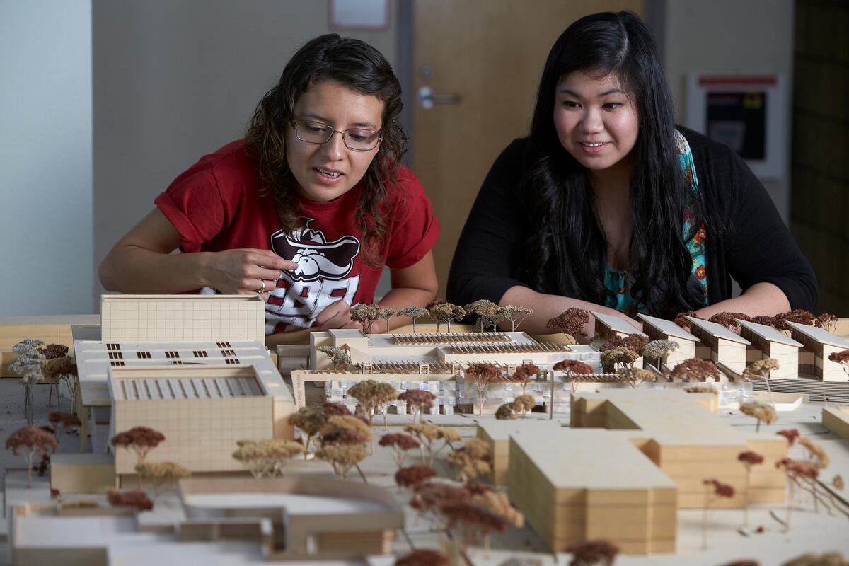 Two students look over building models