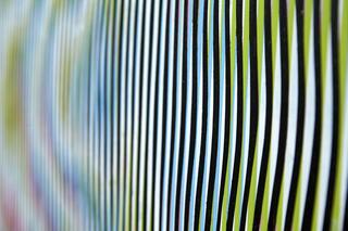 A close-up view of slightly curved stripes colored green, blue, and black. They are almost--but not quite--aligned.