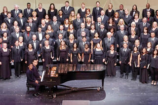 The UNLV Choral Ensembles on the stage of the Artemus W. Ham Concert Hall.