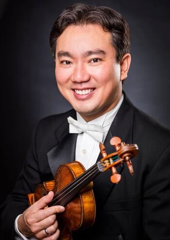 closeup of man in suit holding a violin