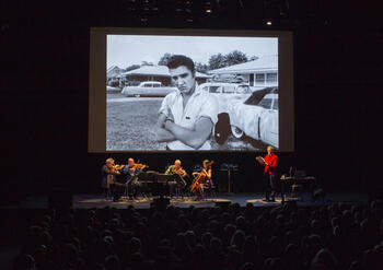 stage screen of a concert hall showing a man