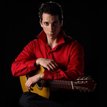 Grisha Goryachev holding an acoustic guitar