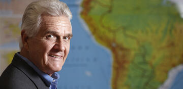 Tom Wright poses in front of a map