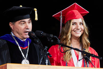 President Len Jessup speaks next to Hannah Kelley