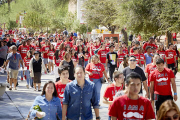 Students in red shirts walking outside on campus