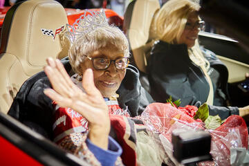 Audrey James rides in the first car in the Homecoming Parade.