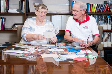 couple at desk filled with holiday cards