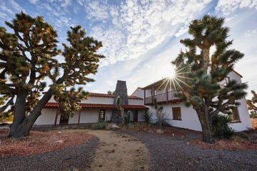 The sun breaks over a ranch house