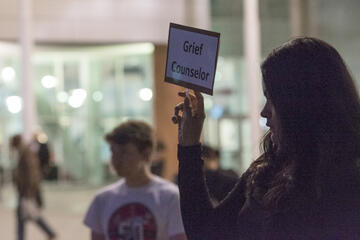 woman holding sign saying &quot;grief counselor&quot;