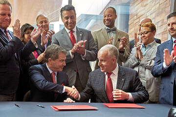 UNLV President Len Jessup, left, and Tesla Motors Vice President for Business Development Diarmuid O’Connell shake hands