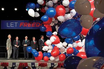 balloons fall from the ceiling at the debate announcement press conference