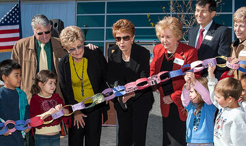 Mrs. Harter standing alongside other during the ribbon-cutting ceremony.
