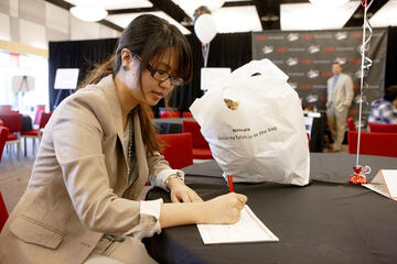Young woman focused and writing a letter to a donor.