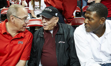 Tarkanian talks with former UNLV President Neal Smatresk and former player Larry Johnson at a UNLV basketball game.