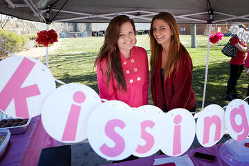 Manning the "Kissing Booth" for Zeta Tau Alpha are Lexi Bates, left, and Lindsay Zeiger. The ZTAs are raising money for breast cancer education awareness.