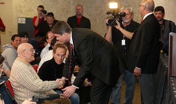 In 2011, Tarkanian greets Dave Rice, a former player, at the media conference announcing Rice's hiring as the Runnin' Rebels coach.