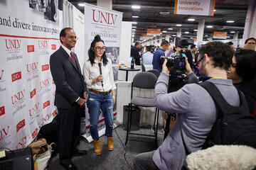 Dean Rama Venkat at a UNLV Engineering booth being interviewed by media.