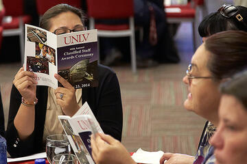 Person focused on a UNLV brochure.