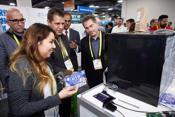 Michelle Mata explaining and demonstrating the smart microwave project she and her peers developed to several attendees.