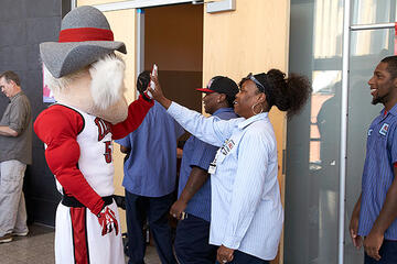 Hey Reb mascot giving high fives to employees.