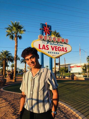Wyeth Olivas stands in front of the iconic "Welcome to Fabulous Las Vegas" sign