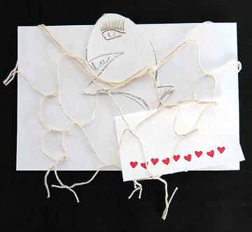Abstract travel collage by Alisha Kerlin named fish containing a drawn fish, card stock with a hearted border, and twine.
