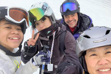 A man in ski gear stands with his children